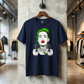 Ciemnogranatowa koszulka unisex z wyrazistym nadrukiem w stylu urban art, prezentowana na drewnianym wieszaku w nowoczesnym wnętrzu butiku. Grafika przedstawia kobietę z neonowozielonymi włosami i czerwonymi ustami, trzymającą dwa pistolety skierowane do przodu. Projekt łączy estetykę pop art z tatuażowymi detalami, takimi jak motyw piramidy na szyi postaci.