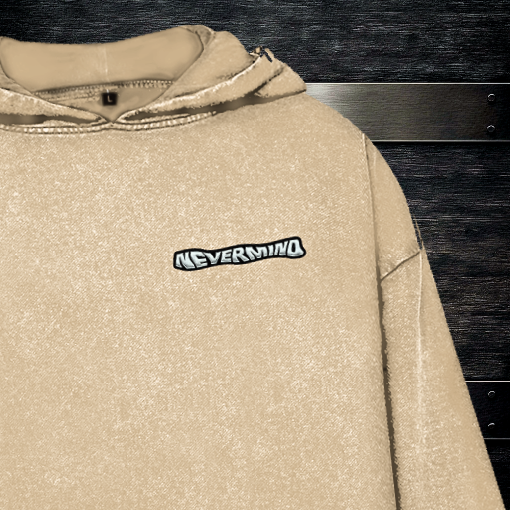 Detal logotypu NEVERMIND na piersi beżowej bluzy o teksturze washed cotton, setup urban desk.